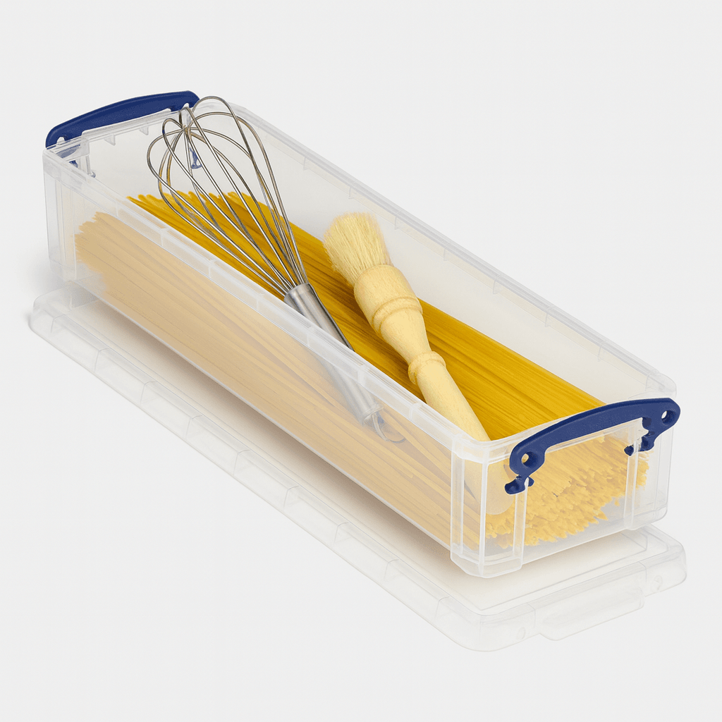 Clear container with pasta, whisk, and brush on a white background