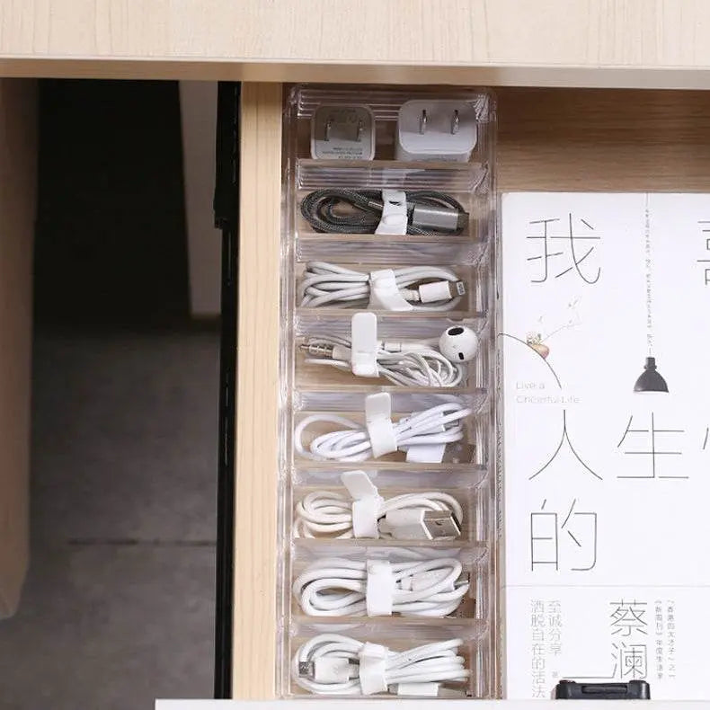 Clear cable organizer inside a wooden drawer with various cables.