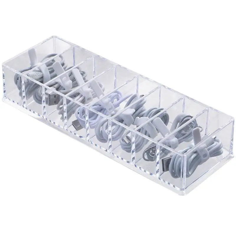 Clear cable organizer with multiple compartments holding white cables on a white background