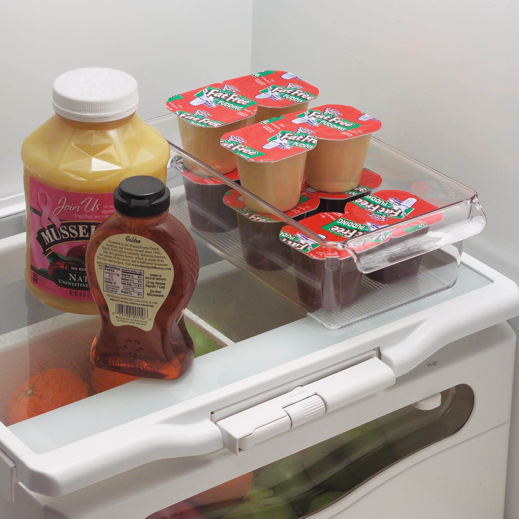 iDesign Fridge organizer with containers, a bottle, and a jar on a refrigerator door.