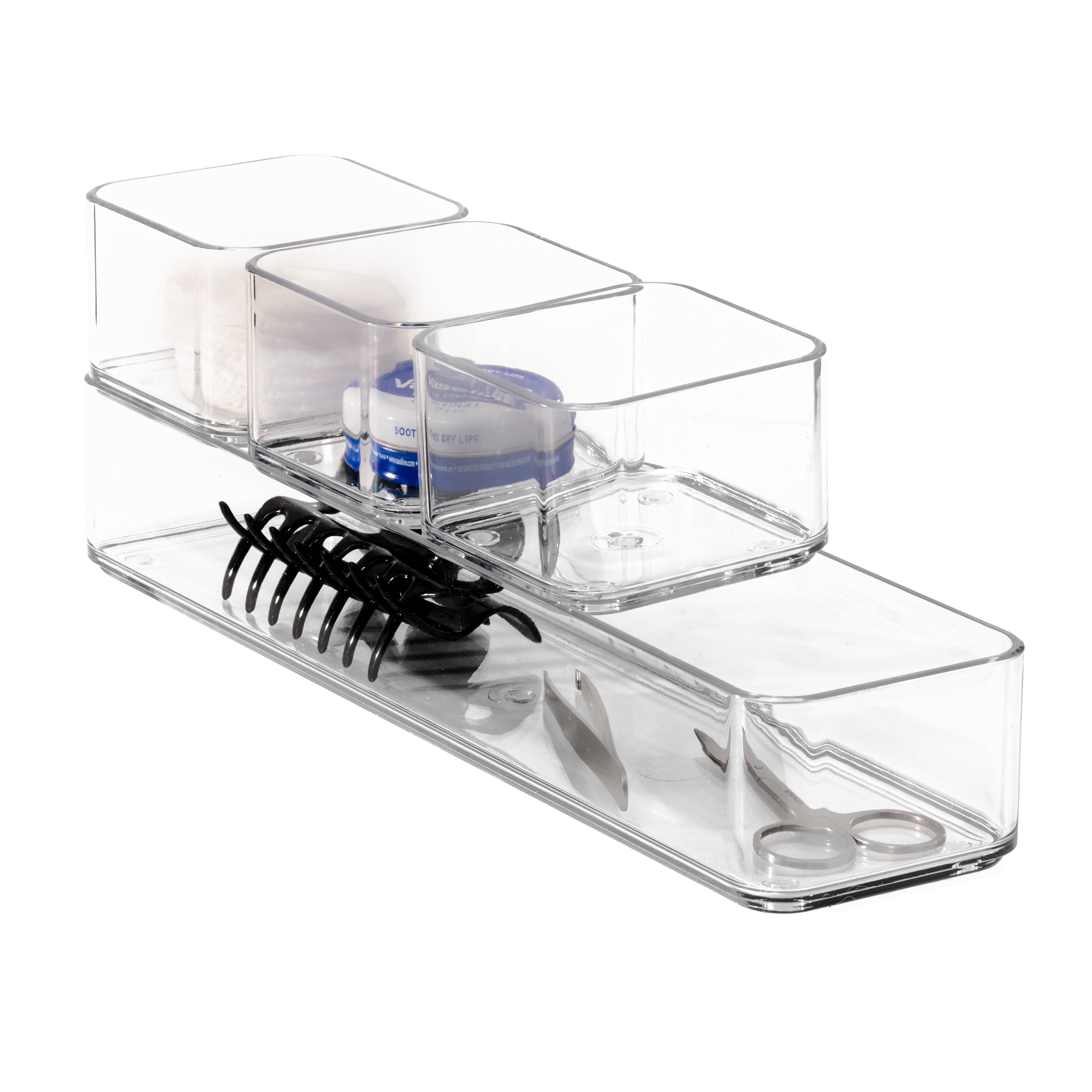 Clear plastic organizers containing a comb, scissors, and other small items on a white background.