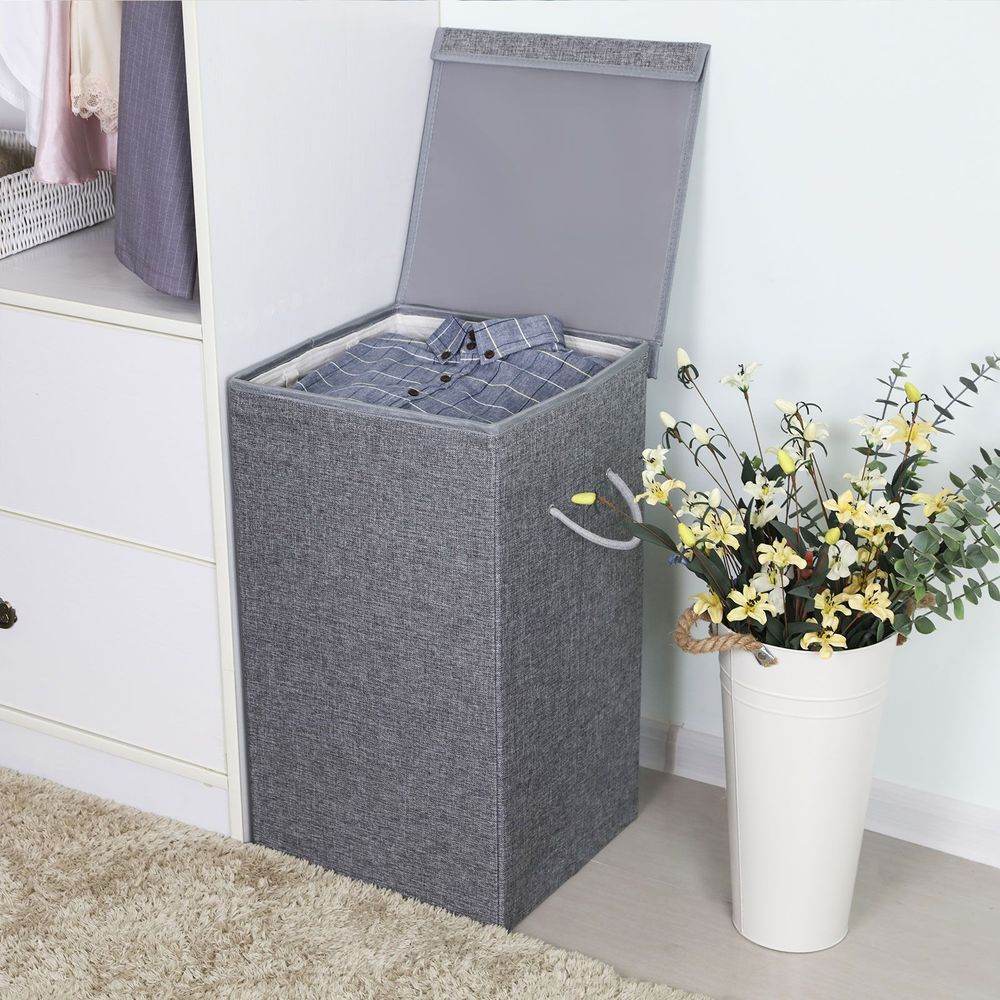 Songmics Laundry Hamper 85 L in a corner with cloth inside.