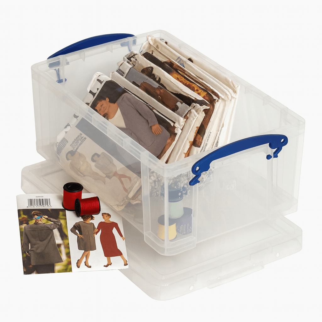 Really Useful Box 9 Litre Clear photo storage box with blue handles containing various photographs on a white background